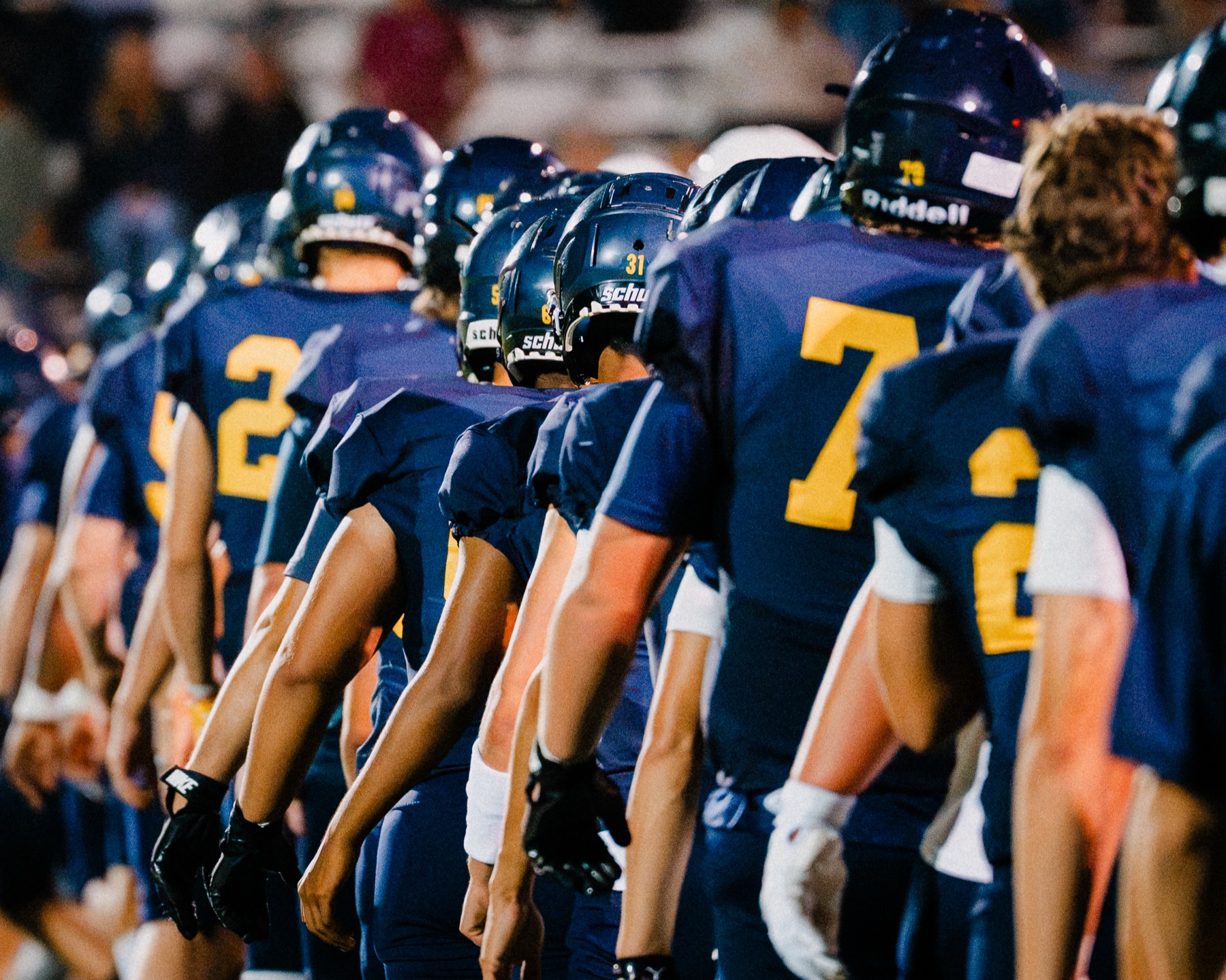 Arroyo Grande players lined up together, heads down, before the game