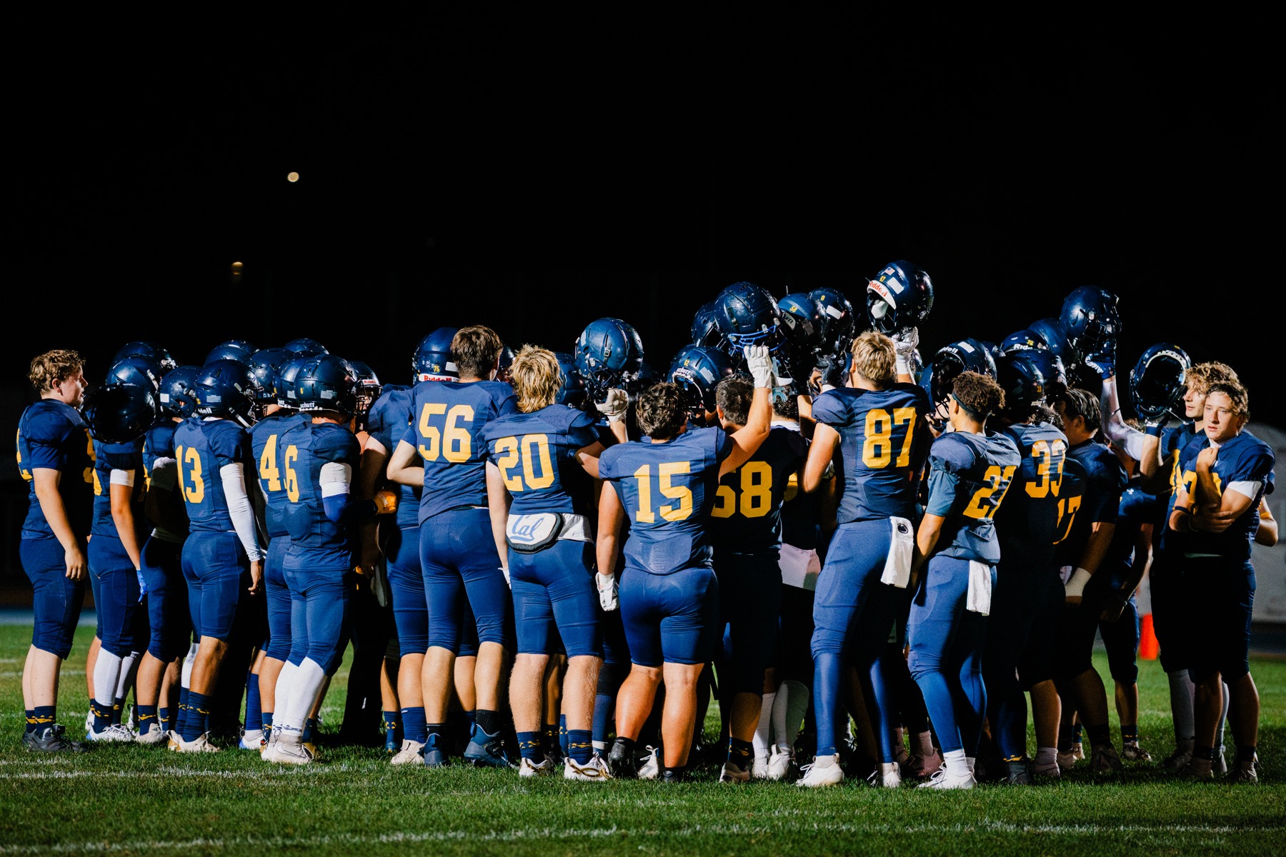 Arroyo Grande's team huddles together under the stadium lights