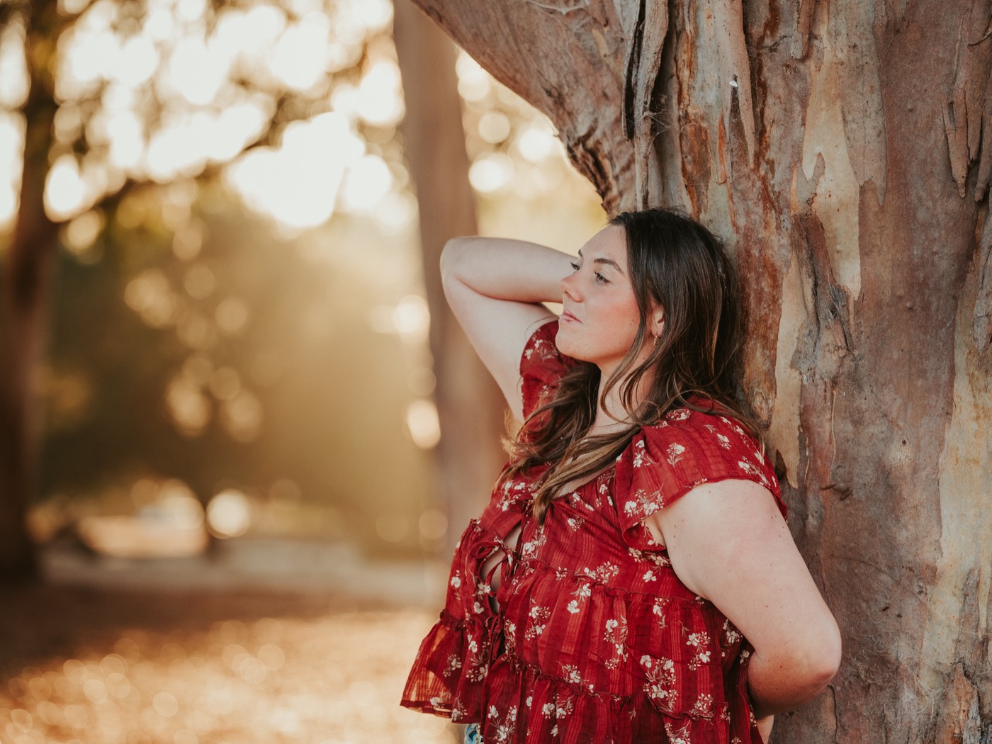 Senior portrait leaning against a sunlit eucalyptus tree — Central Coast senior photographer
