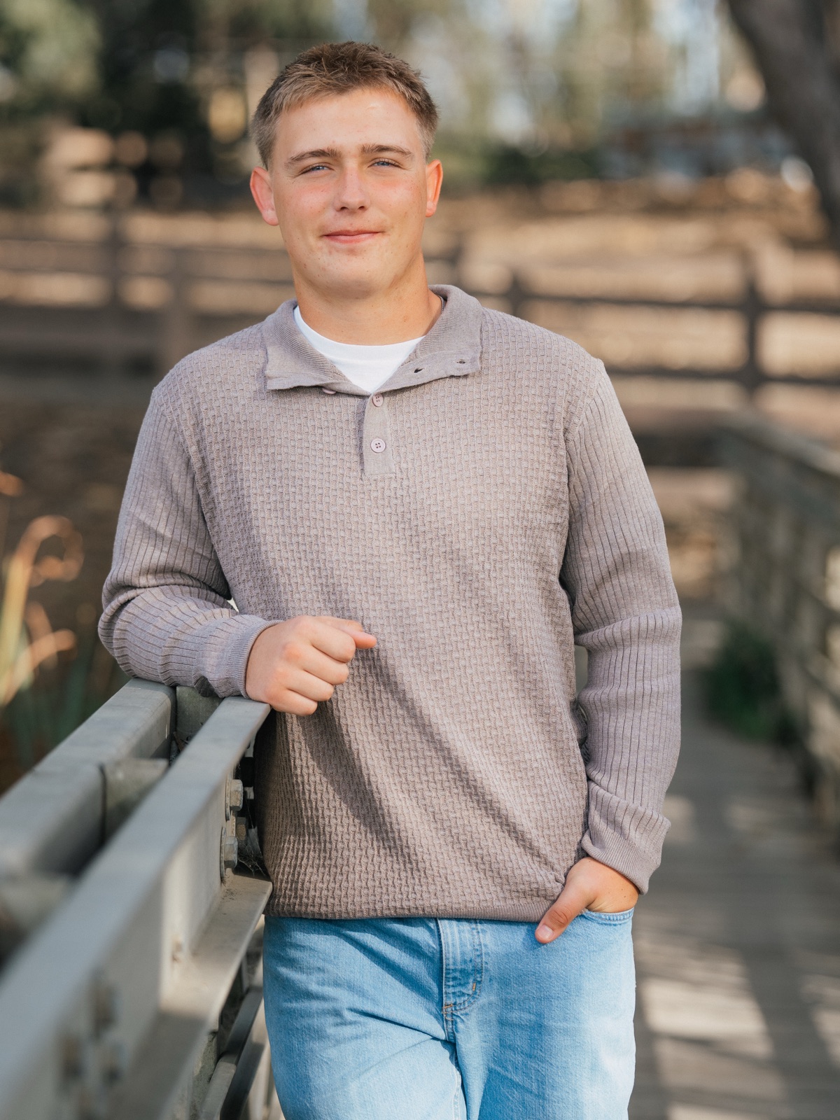 Senior in a striped flannel, hands in pockets, standing in a golden field — Central Coast senior photographer