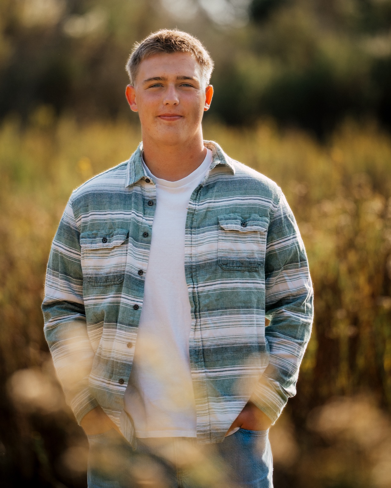 Senior in a knit sweater leaning on a boardwalk railing with a relaxed smile — Central Coast senior photographer