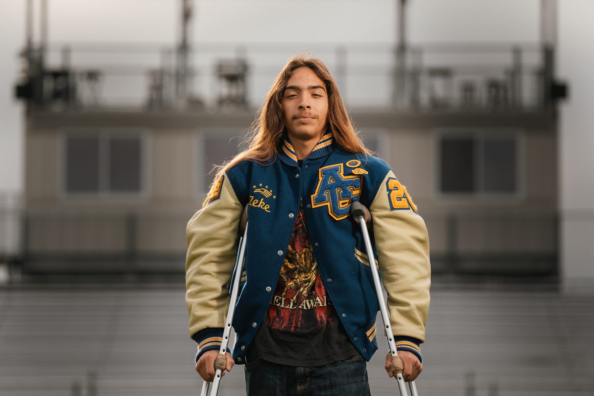 Senior boy in letterman jacket on crutches, Arroyo Grande